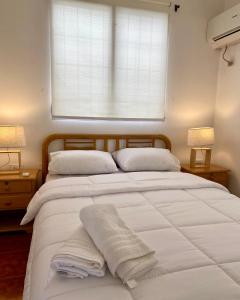 a bedroom with a large white bed with a window at Las Casitas en Salinas in Salinas