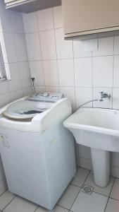 a white bathroom with a toilet and a sink at Apartamento TOP CLIMATIZADO em CRICIÚMA-SC - ótimo CUSTO-BENEFÍCIO - Cozinha completa - Cama Box - WiFI - Smart TV - Apps YouTube - NetFlix - Prime Vídeo - Garagem coberta - Portaria Digital 24h - Lugar sossegado e arborizado - Acomoda até 5 pessoas in Criciúma +22 photos
