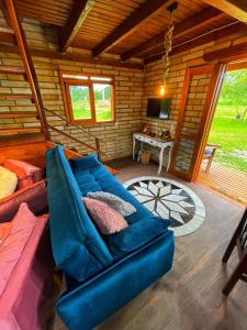 a living room with a blue couch in a log cabin at Chalé de Pedra Recanto Verde dos Canyons in Praia Grande
