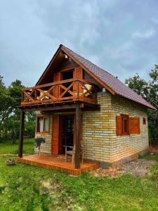 a small house with a porch on a field at Chalé de Pedra Recanto Verde dos Canyons in Praia Grande