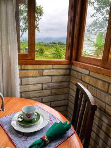 - une table avec une tasse de café et une fenêtre dans l'établissement Chalé de Pedra Recanto Verde dos Canyons, à Praia Grande