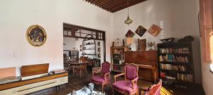 a living room with a piano and purple chairs at San Felipe el Real in Chihuahua