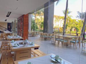 a restaurant with wooden tables and chairs and windows at Wanda Realm Resort Sanya Haitang Bay in Sanya