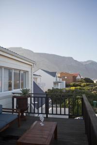 una terraza de madera con una mesa y una copa de vino en Villa Del Mar, en Clareport 30 fotos más