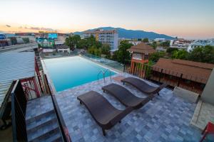 a swimming pool with lounge chairs on top of a building at WE Terminal Hotel in Chiang Mai