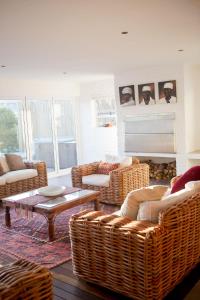 a living room with wicker chairs and a table at Villa Del Mar in Clareport