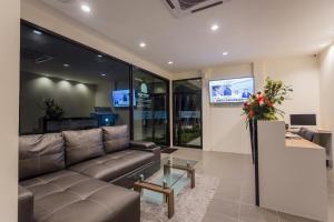 a living room with a couch and a tv at Journey Residence Phuket in Bang Tao Beach