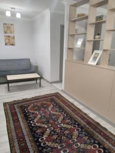 sala de estar con sofá y alfombra en Izmir Apartment, en Baku