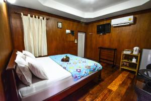 um quarto com uma cama e uma televisão em Pruksa Resort Prachin Buri em Prachin Buri