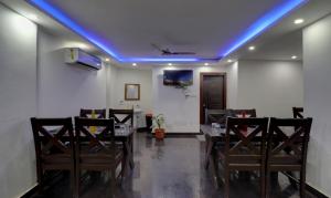 a dining room with a blue light on the ceiling at Itsy By Treebo - NV in Rishīkesh