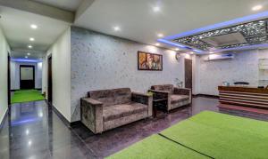 a lobby with two chairs and a table and green carpet at Itsy By Treebo - NV in Rishīkesh