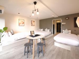 a bedroom with two beds and a table and stools at Lestel Maru in Sapporo