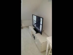 TV de pantalla plana en la parte superior de un armario blanco en Stunning Loft Apartment Air conditioning, impressive modern conversion, en Alicante