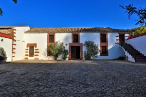 - une vue sur l'extérieur d'une maison avec une allée dans l'établissement Casa Rural COMPLETA Finca Los Conventos en Adamuz; Córdoba, à Adamuz