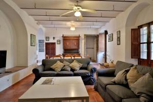 - un salon avec des canapés et un ventilateur de plafond dans l'établissement Casa Rural COMPLETA Finca Los Conventos en Adamuz; Córdoba, à Adamuz