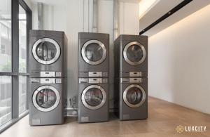 a group of four washing machines in a room at Luxcity Hotel & Apartment in Phnom Penh