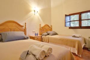 - une chambre avec 2 lits et une fenêtre dans l'établissement Casa Rural COMPLETA Finca Los Conventos en Adamuz; Córdoba, à Adamuz