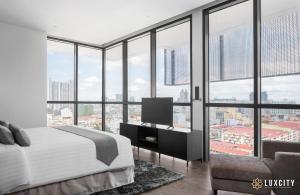 a bedroom with a bed and a view of a city at Luxcity Hotel & Apartment in Phnom Penh