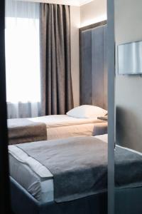 チュメニにあるHotel Turaのベッド2台と窓が備わるホテルルームです。