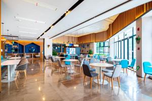 a restaurant with tables and chairs and windows at Holiday Inn Express Pinghu by IHG in Pinghu