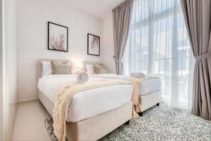 a bedroom with two beds and a large window at Charismatic 3BR Townhouse at DAMAC Hills 2 Dubailand by Deluxe Holiday Homes in Dubai