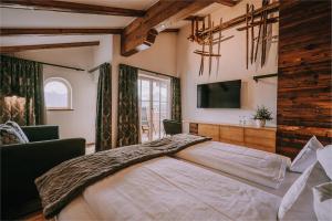 a bedroom with a large bed and a television at Alpe Dornach in Oberstdorf +47 photos