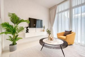 sala de estar con mesa, silla y TV en Charismatic 3BR Townhouse at DAMAC Hills 2 Dubailand by Deluxe Holiday Homes, en Dubái