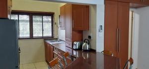 HAPPY HOUSE @ 16 في سانت لوسيا: مطبخ مع خزائن خشبية وثلاجة سوداء