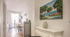 un baño blanco con cocina y una pintura en la pared en Castellabate Apartments Casa Maddalena, en Castellabate