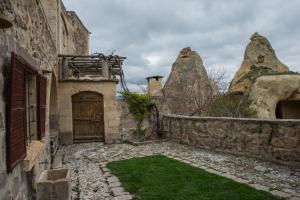 un antiguo edificio de piedra con una puerta y un patio en Les Maisons De Cappadoce, en Uchisar