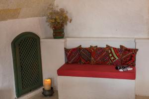 un banco con almohadas y una vela en una habitación en Les Maisons De Cappadoce, en Uchisar