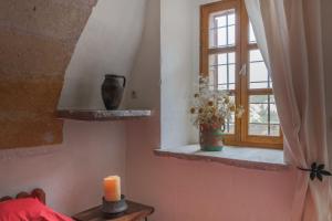Cette chambre dispose d'une fenêtre avec un vase et une bougie. dans l'établissement Les Maisons De Cappadoce, à Uçhisar