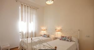 1 dormitorio con 2 camas y ventana en Castellabate Apartments Casa Maddalena, en Castellabate