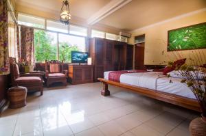 1 dormitorio con 1 cama y TV en Melasti Kuta Bungalows & Spa, en Kuta