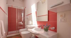 y baño con lavabo, aseo y espejo. en Castellabate Apartments Mansarda Maddalena, en Castellabate