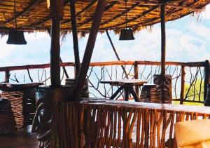 a large straw hut with a table and chairs at Dreamville Hostel in Ella