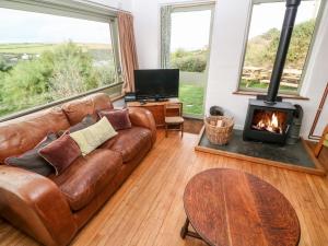 a living room with a couch and a fireplace at Porth Farm Annexe in Newquay