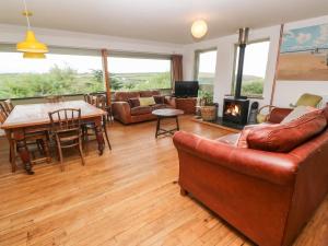 a living room with a couch and a table and a fireplace at Porth Farm Annexe in Newquay