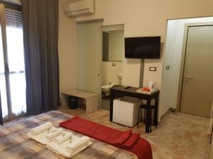 een hotelkamer met een bed, een bureau en een televisie bij B&B Monté in Montesilvano