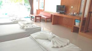 ein Hotelzimmer mit drei Betten und einem Fernseher in der Unterkunft Z-Touch Lipe Island Resort in Ko Lipe + 44 Fotos