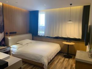 Postel nebo postele na pokoji v ubytování 银座佳驿精致酒店（济阳汽车总站店）