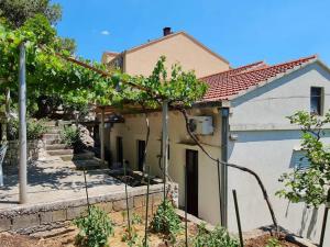 a house with a tree in front of it at Apartments Maruška in Sobra