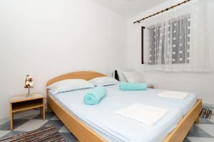 Cama en habitación con pared blanca en Apartments Maruška, en Sobra