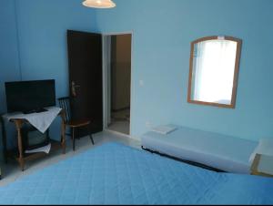 Habitación azul con cama, mesa y espejo en Apartments Maruška, en Sobra