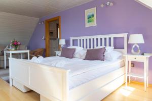 CsórにあるFiastyúk Udvarházの紫の壁の白いベッドが備わるベッドルーム1室