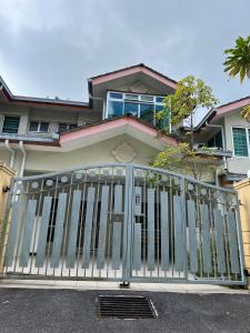 ein Haus mit einem Tor davor in der Unterkunft Jarzmin Double Story Homestay @ Royal Lily in Tanah Rata