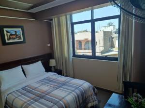 a bedroom with a bed and a large window at Hotel Santa Maria in Ica +68 photos