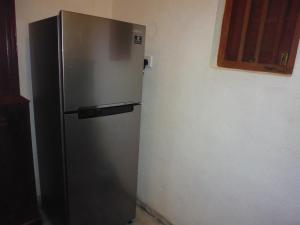 um frigorífico de aço inoxidável no canto de um quarto em Lanrich Eco Villas em Mirissa