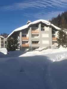 een gebouw met sneeuw op de grond ervoor bij Ansàna in Lenz