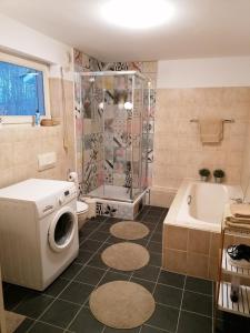 een badkamer met een douche en een wasmachine bij House of Grimm in Hamburg